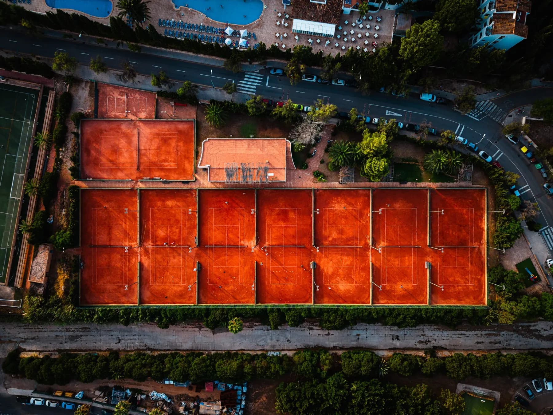 Vista cenital de las pistas del club con la piscina del hotel al borde